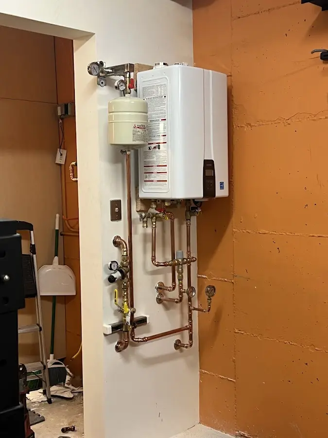 Plumbing technician inspecting water heater connections in Bellaire